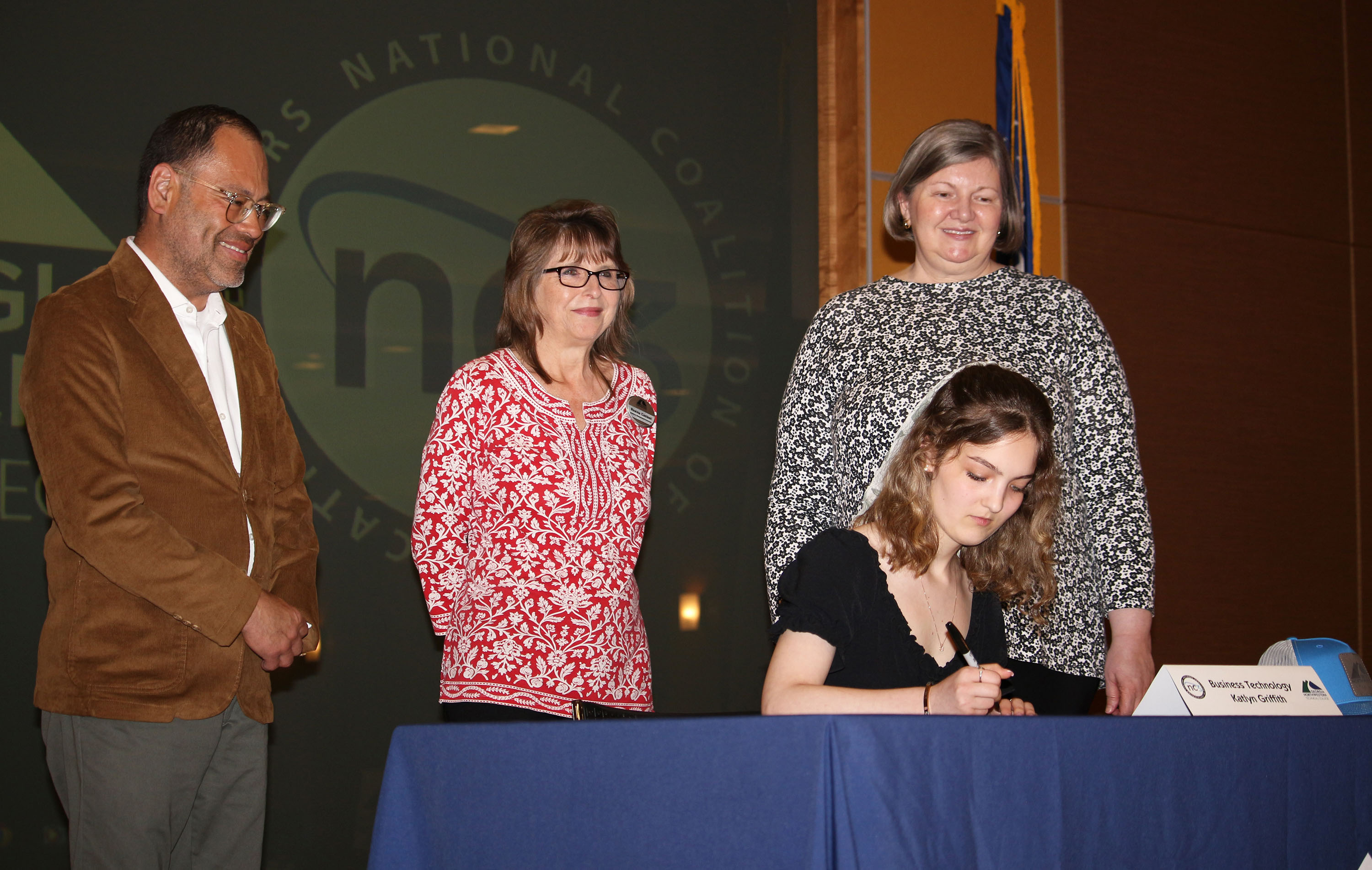 Katlyn Griffith signs her Letter of Intent to study Business Technology as GNTC instructors (from left) Leyner Argueta, director and instructor of Business Management; Regina Casteel, instructor of Business Management; and Lisa Hunt, director of Business Healthcare Technology, look on.