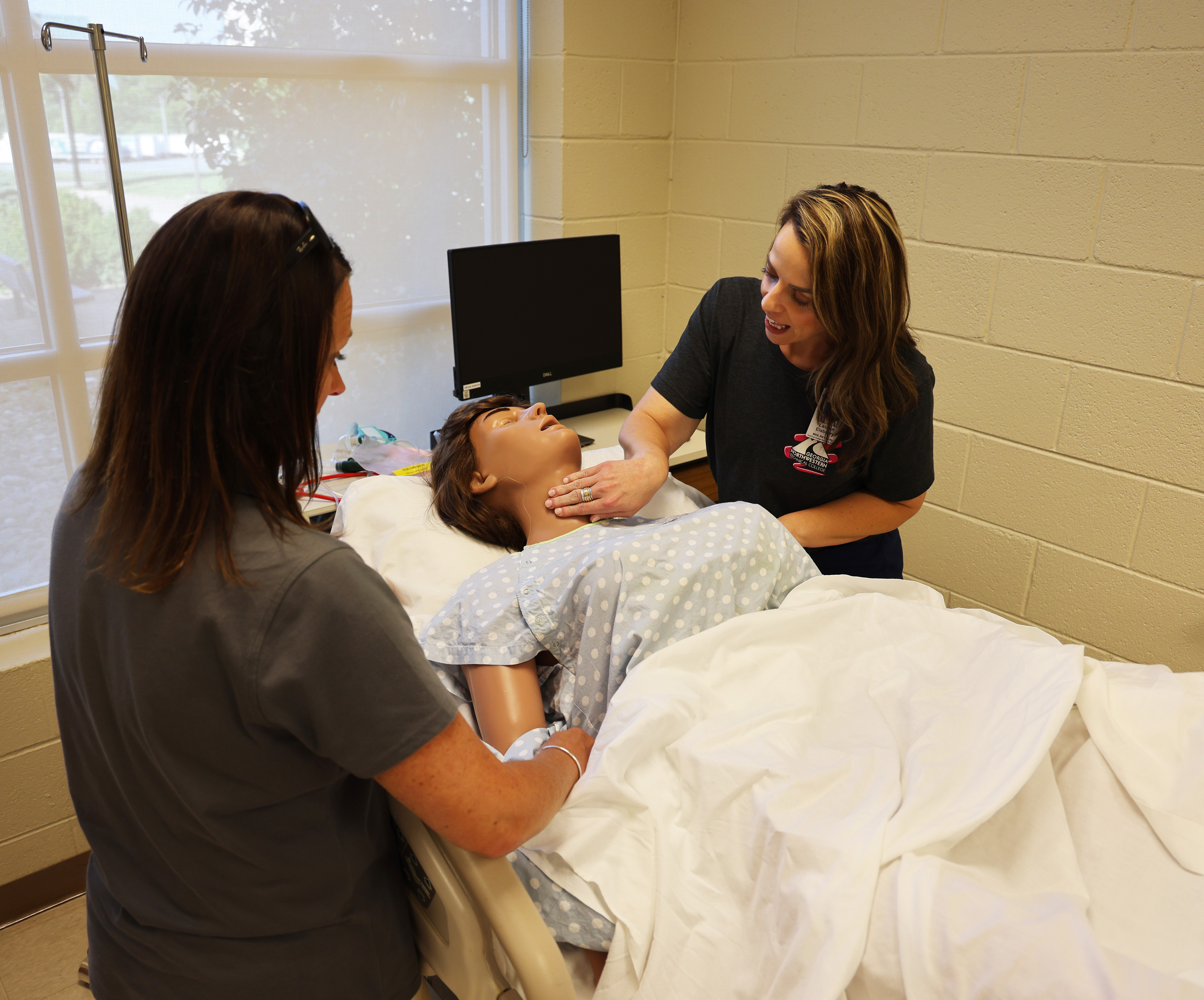 GNTC Associate Degree Nursing instructors Heather Akers (left) and Lauren Elsberry check a manakin’s vital signs during the program’s recent ASN Open House.