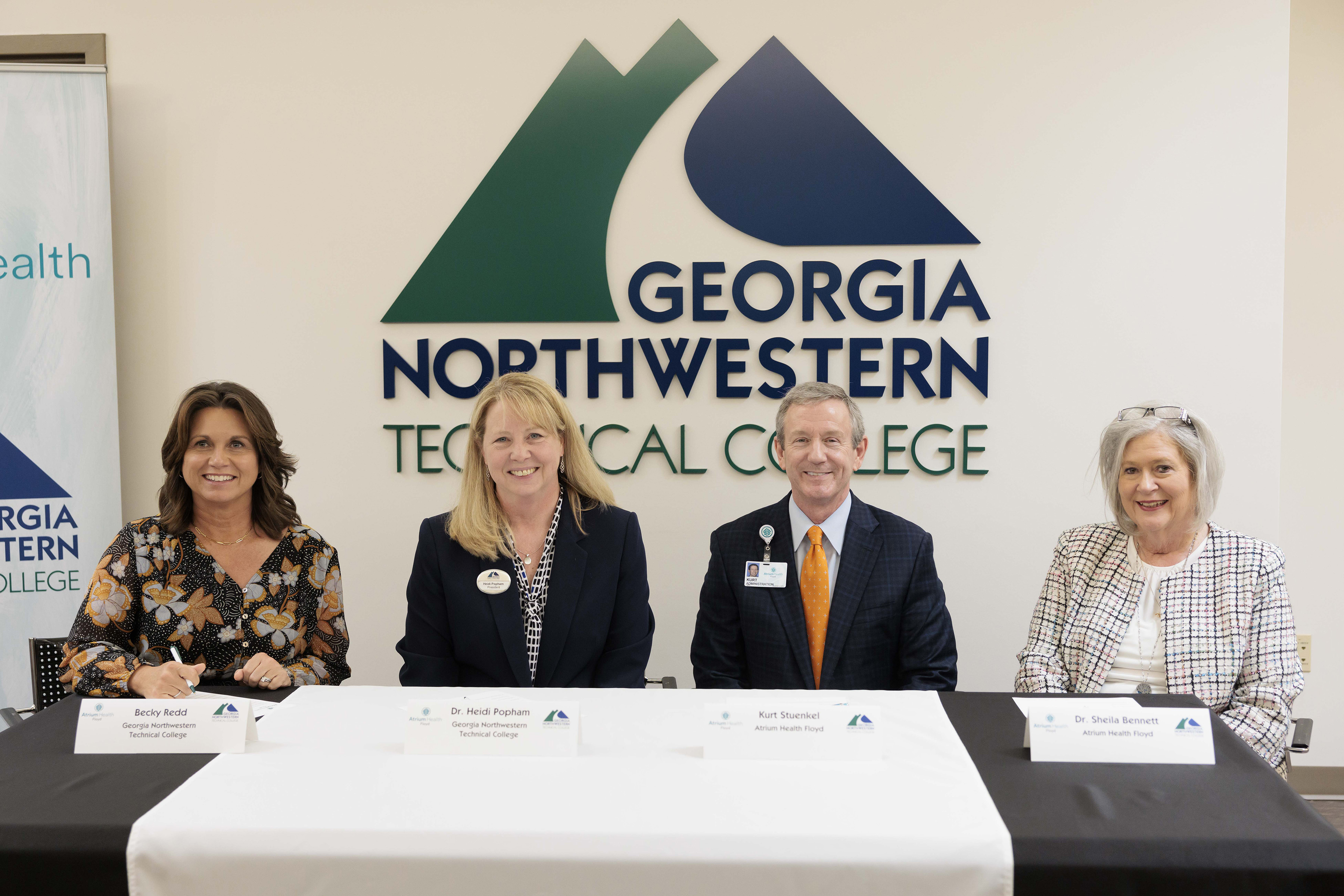 (From left) Becky Redd, GNTC Foundation chair; Dr. Heidi Popham, GNTC president; Kurt Stuenkel, Atrium Health Floyd president; and Dr. Sheila Bennett, Atrium Health Floyd senior vice president and chief of patient services, prepare to sign a new agreement designed to boost enrollment in three of GNTC’s healthcare programs and increase the number of Respiratory Therapists, Radiologic Technologists and Certified Nursing Assistants in the northwest Georgia region.