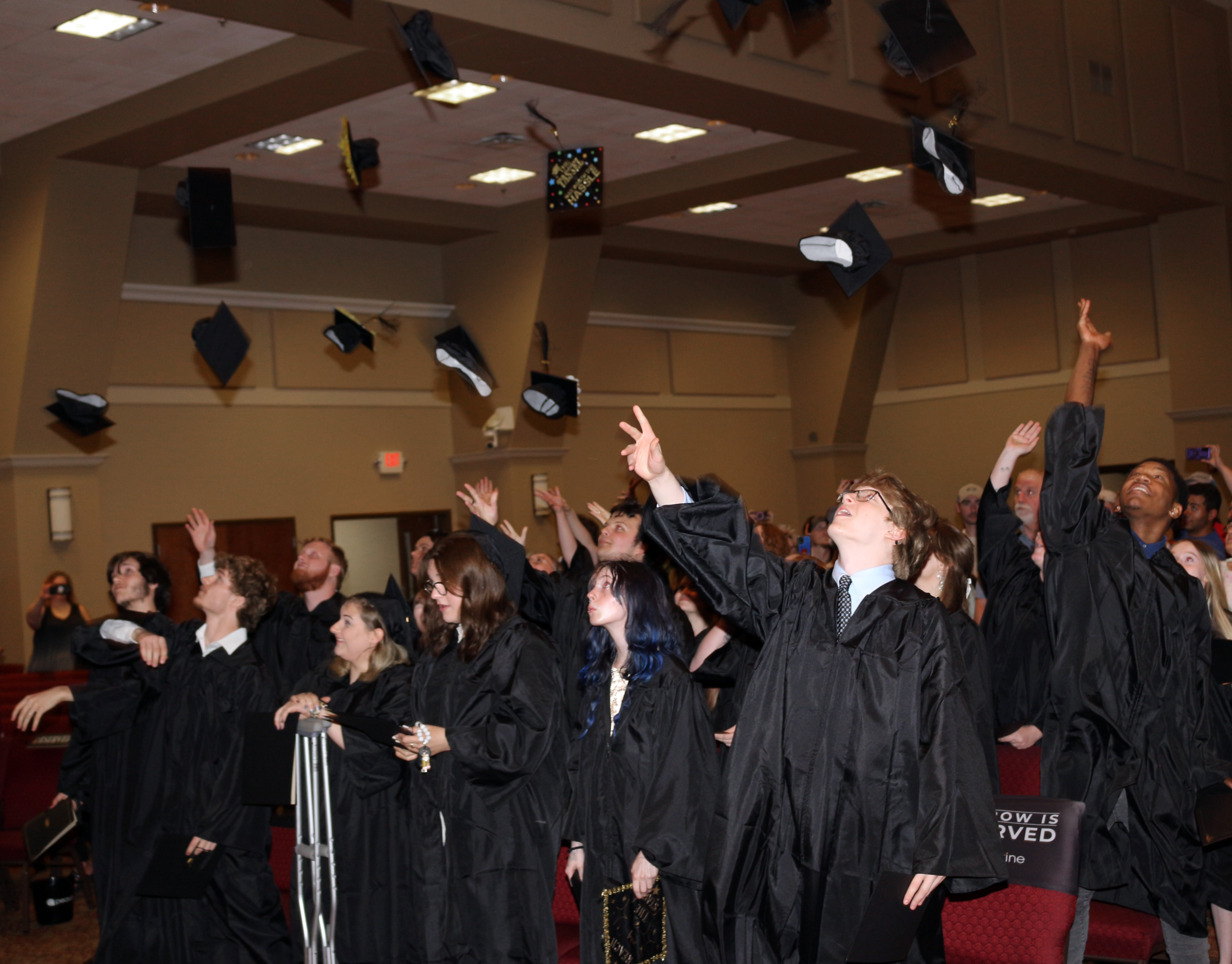 Graduates of GNTC’s Walker County Campus Youth Success Academy celebrate by tossing their graduation caps.